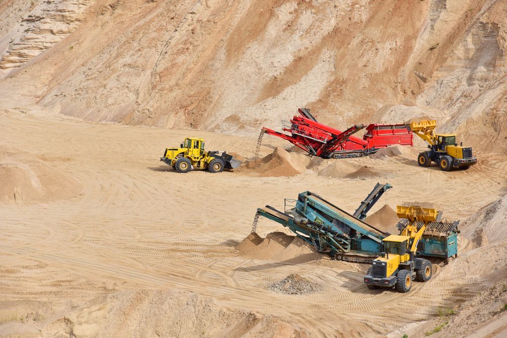 A Group of Trucks Are Working in A Sand Quarry — PBC Compliancing Pty Ltd in Bowen Basin, QLD