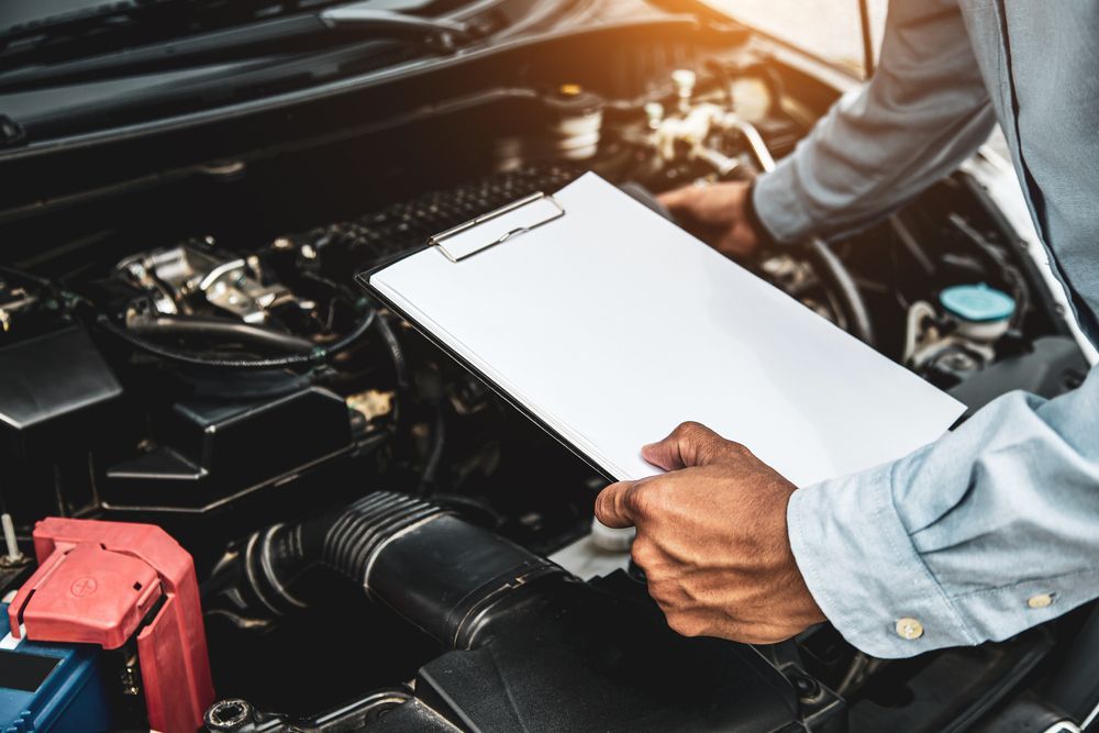 Man Checking The Car While Holding The Clipboard — PBC Compliancing Pty Ltd in Rockhampton, QLD