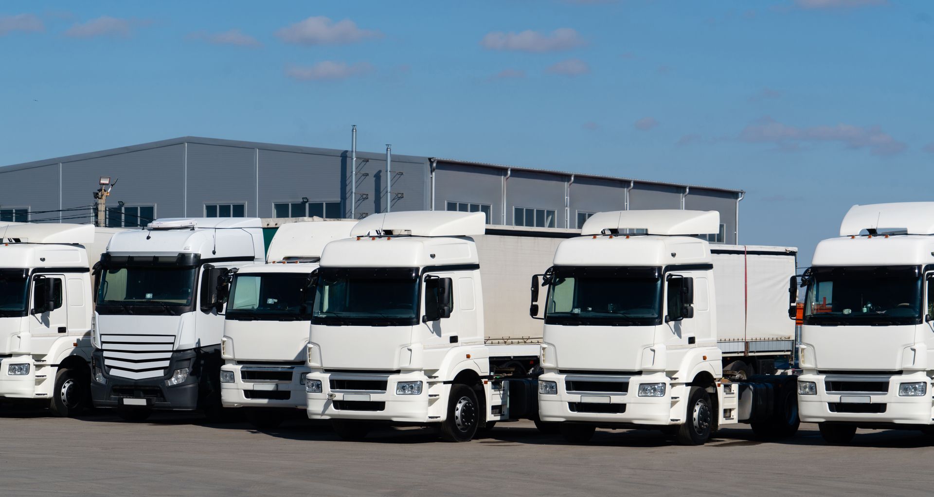 White Semi-trucks Parked in a Lot in Front of a Gray — PBC Compliancing in Dysart, QLD