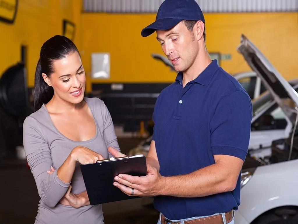 a man in a blue shirt showing a service contract to a woman in a gray shirt - PBC Compliancing