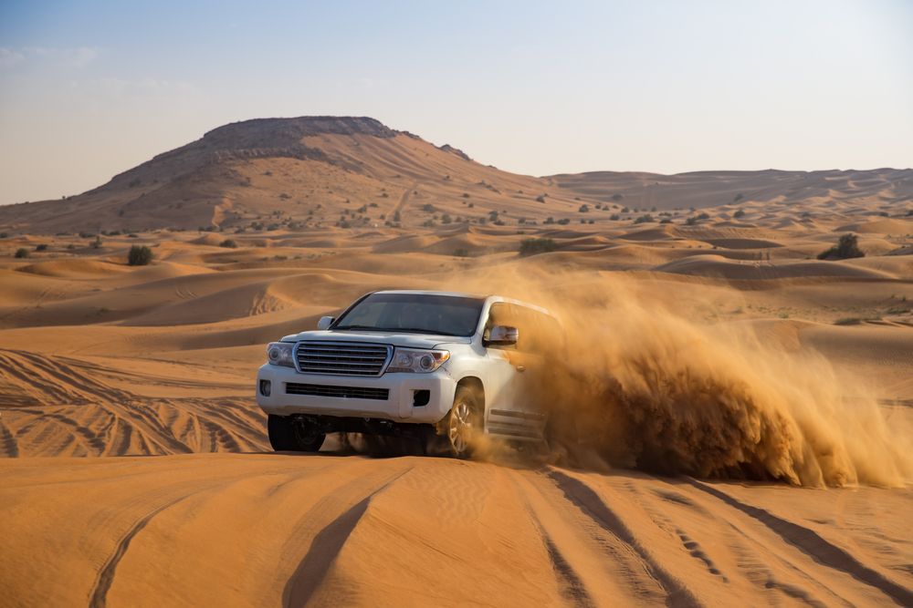 A White suv is Driving Through the sand in the Desert — PBC Compliancing Pty Ltd in Dysart, QLD