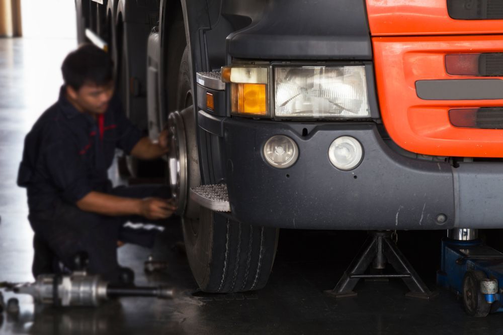 Mechanic Working on the Front Tire — PBC Compliancing in Rockhampton, QLD