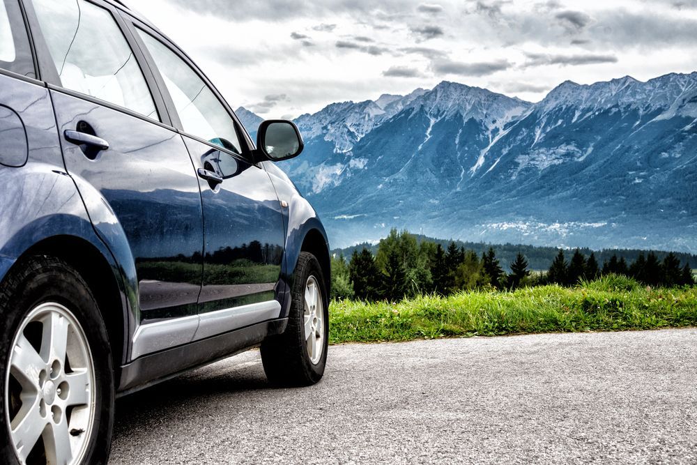 A Car Is Parked on The Side of A Road with Mountains in The Background — PBC Compliancing in Whitsundays, QLD