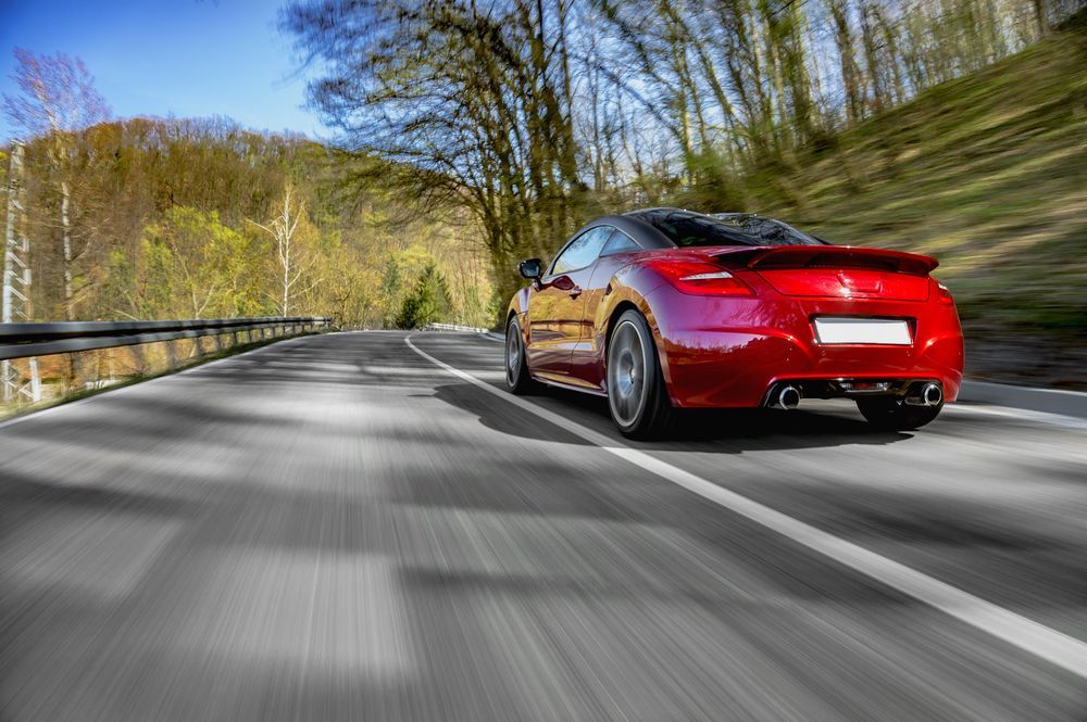 Red Sports Car Driving Fast On The Road — PBC Compliancing Pty Ltd in Townsville, QLD