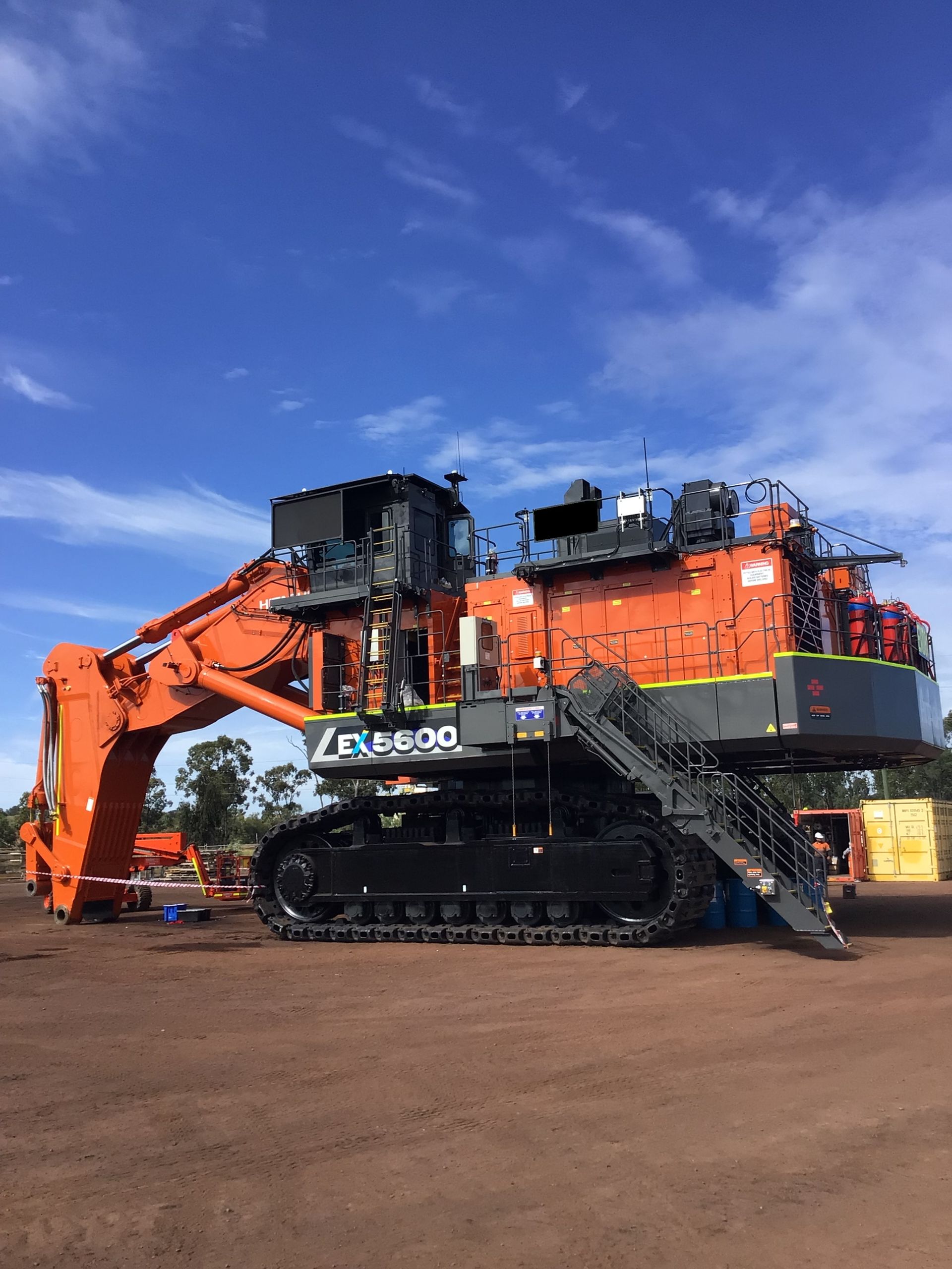 Orange Hitachi Excavator at A Mining Site Against a Blue Sky — PBC Compliancing in Paget, QLD