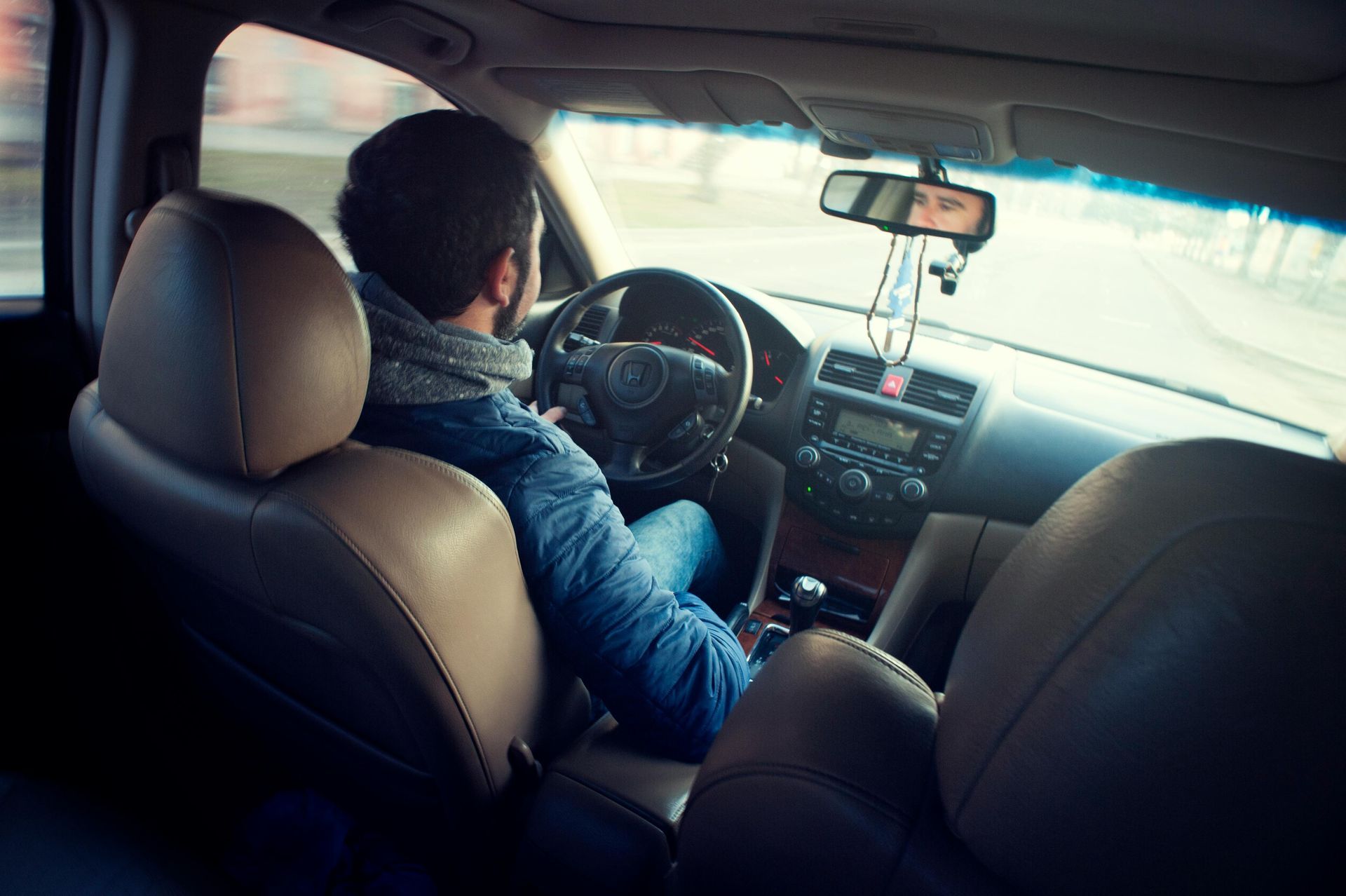 A man is sitting in the driver 's seat of a car.