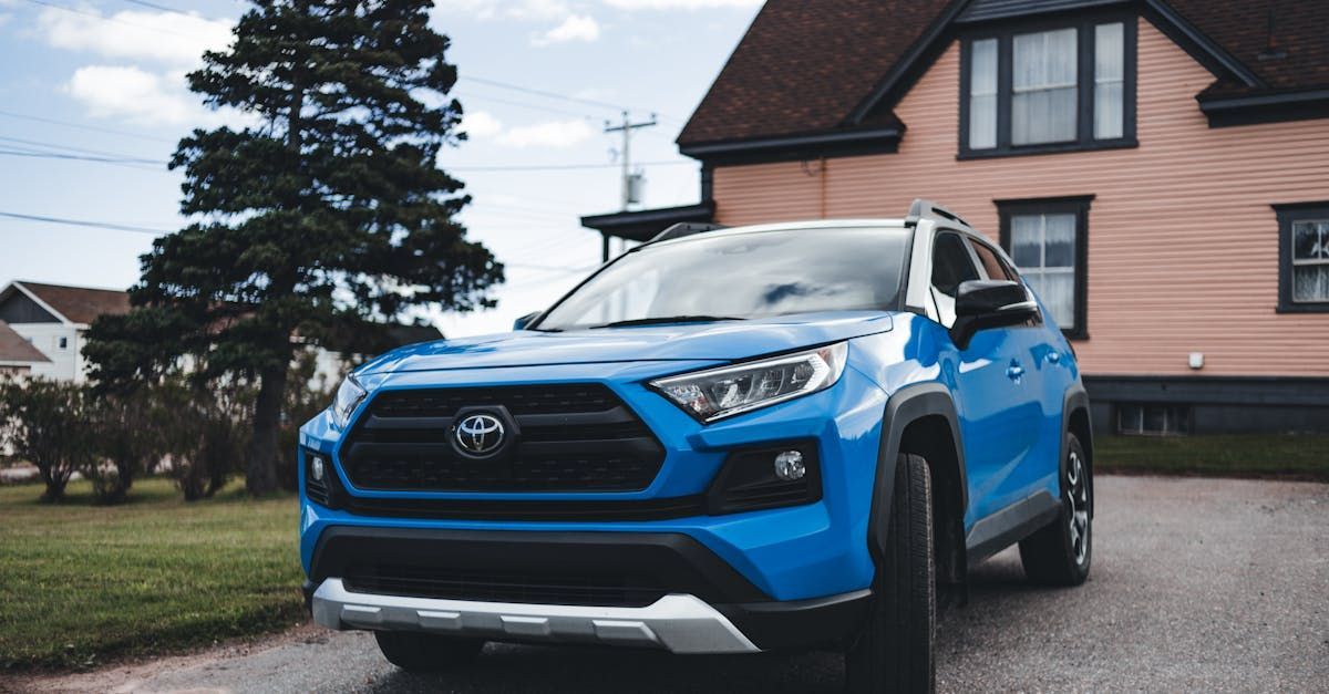 A blue car is parked in front of a house.  | Greens Tire & Auto Center