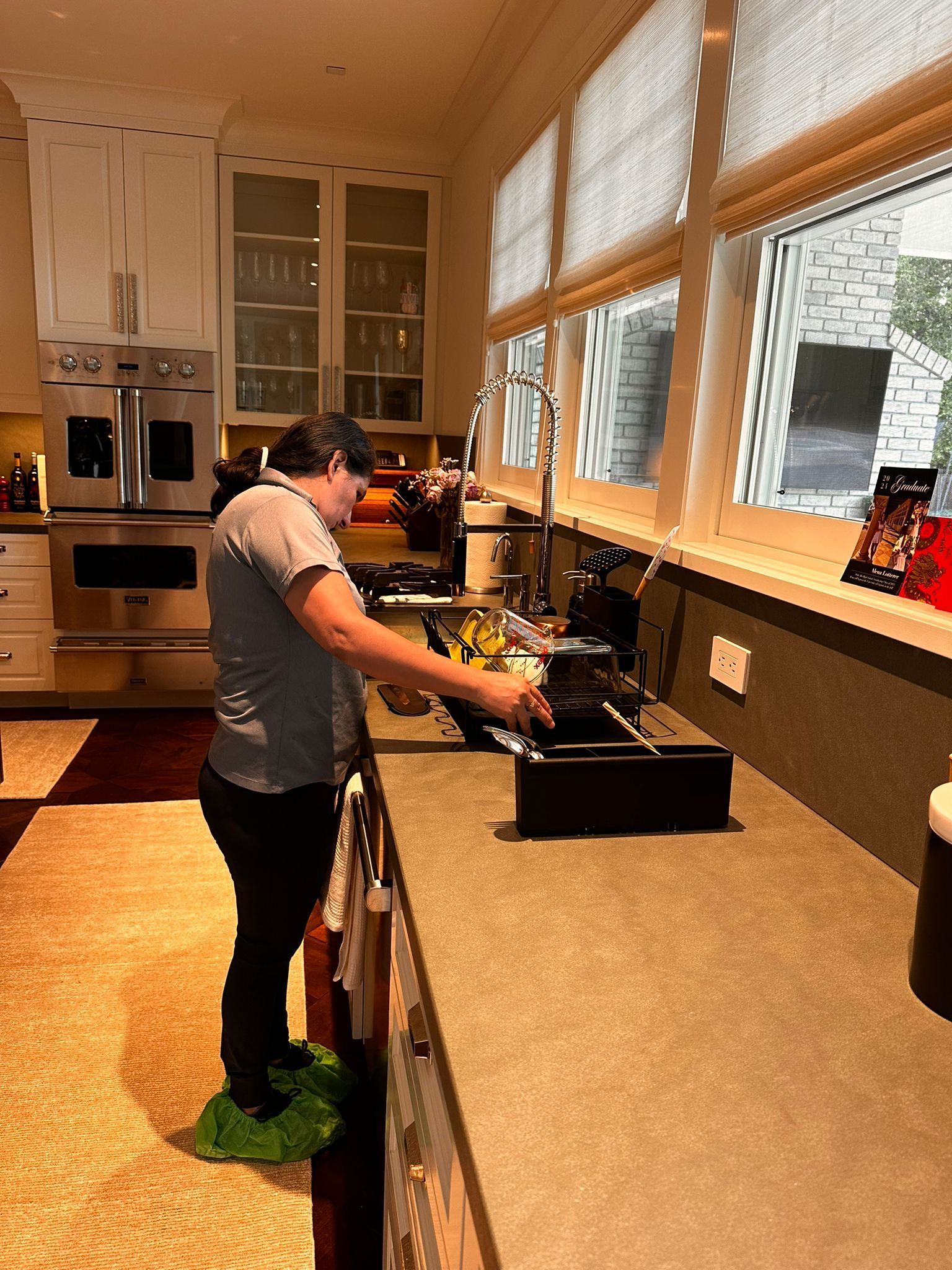 A woman is standing in a kitchen washing dishes