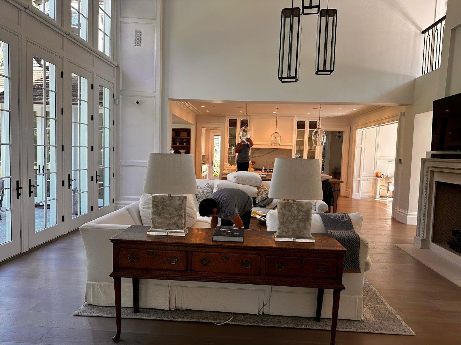 A living room with a couch , table , lamps and a fireplace.
