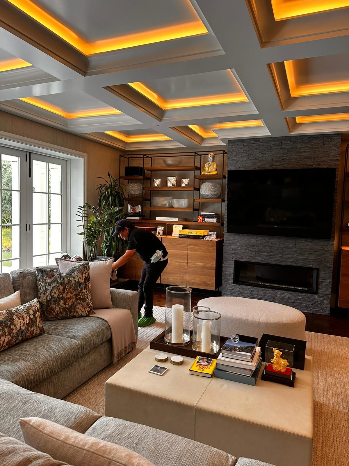 A person is cleaning a couch with a vacuum cleaner.