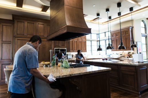 A man is cleaning a kitchen counter with a cloth.