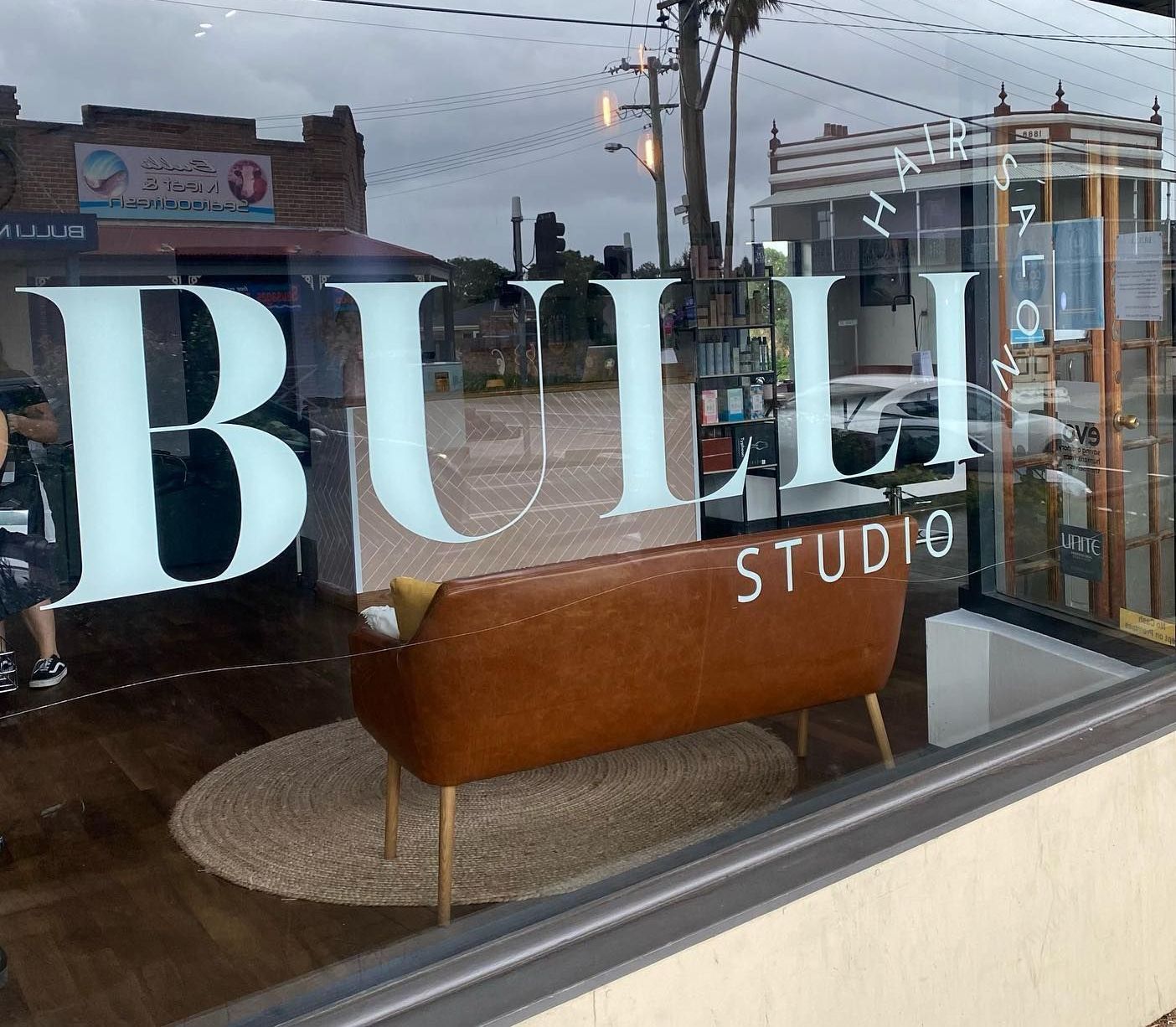 Woman Showing T-shirt with Business Logo — Hair Salon in Bulli NSW