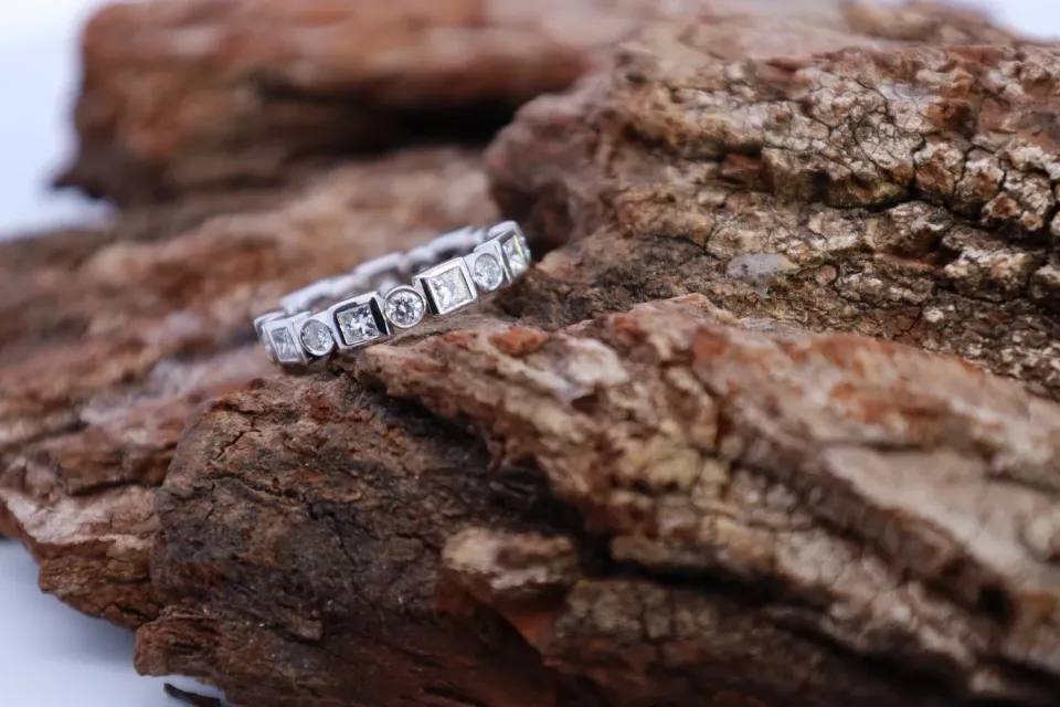 Diamond ring resting on rough brown rock, with shallow focus background