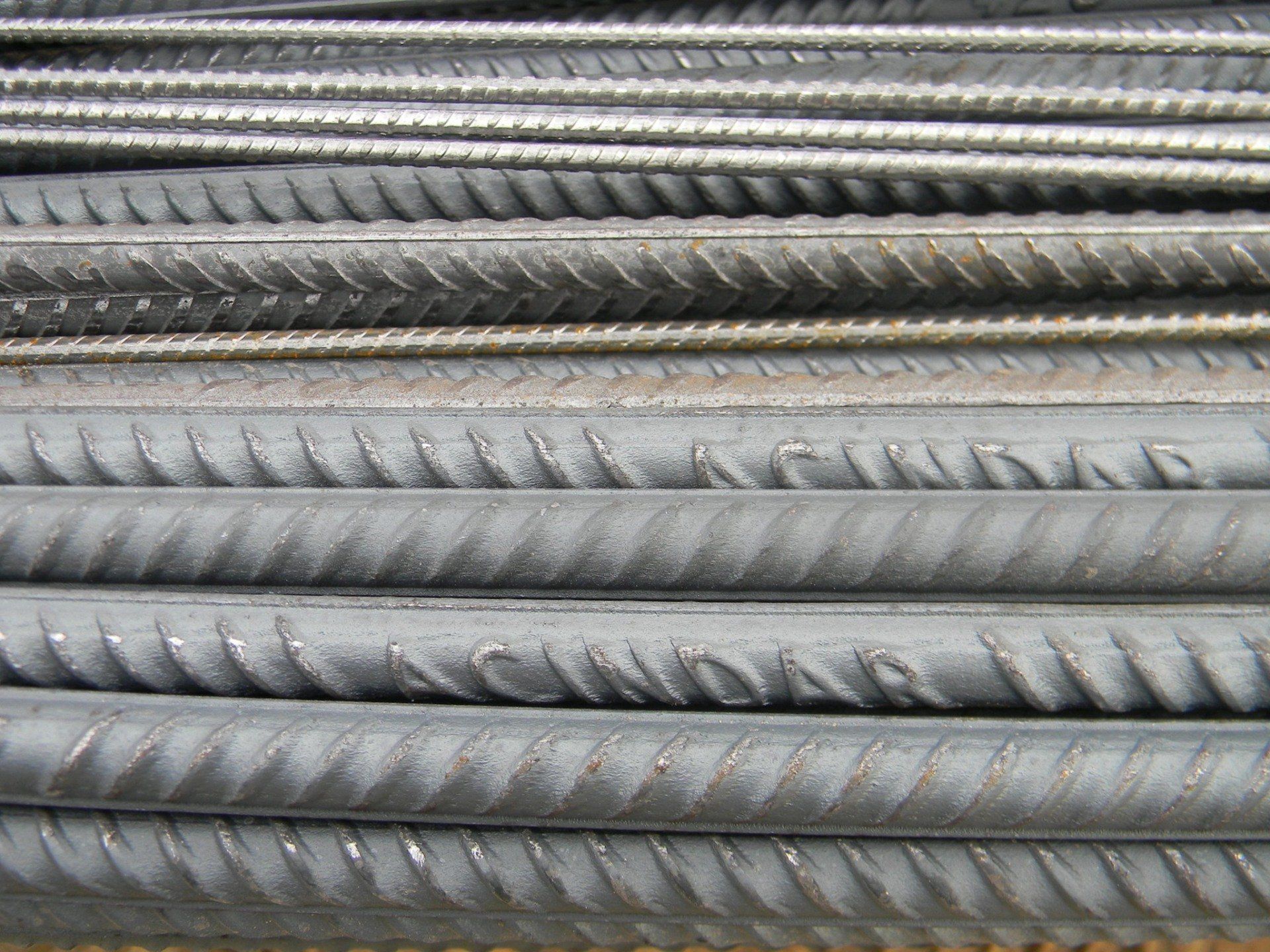 Un primer plano de una pila de barras de acero con la palabra achdar escrita