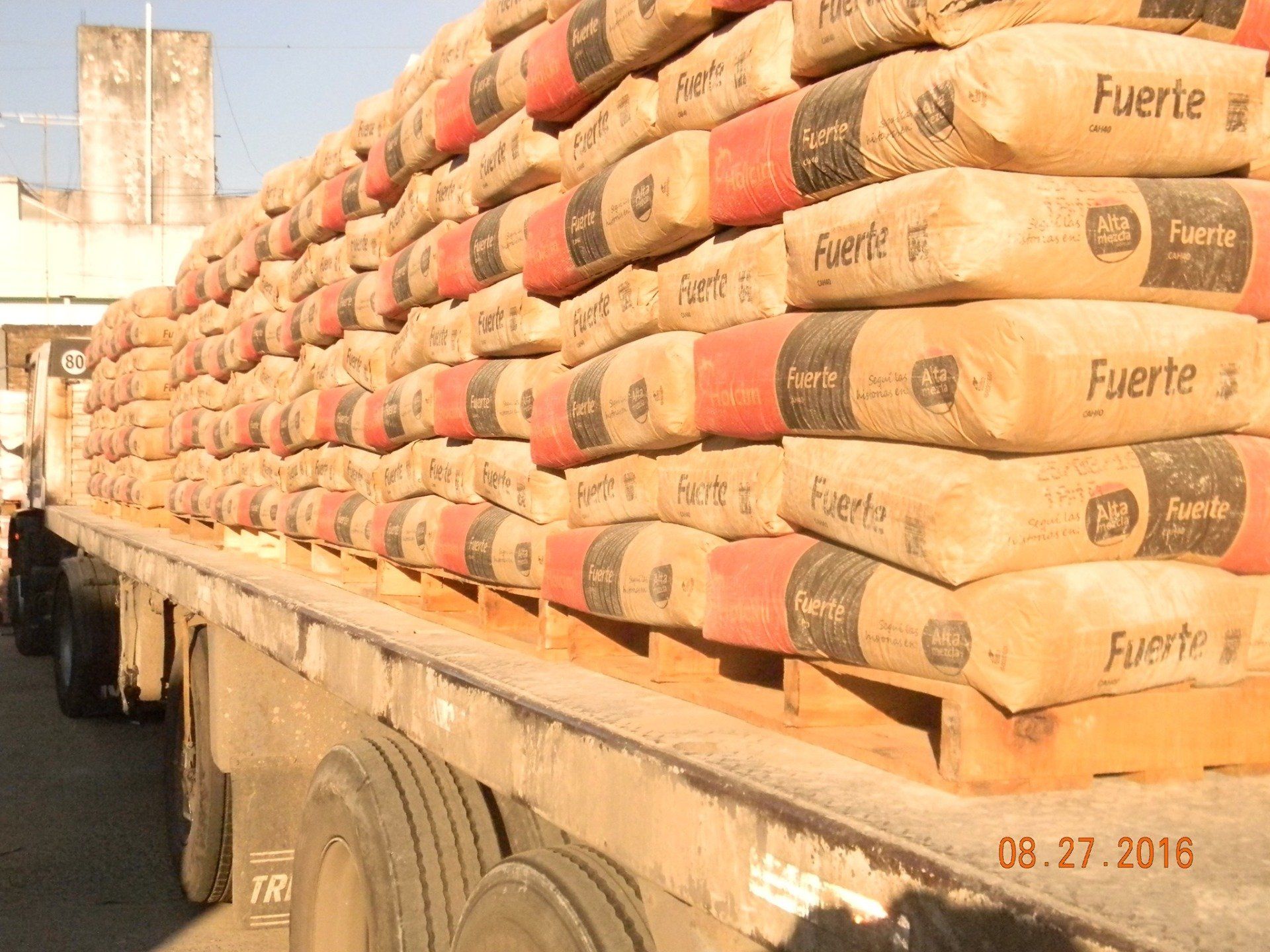 Un camión va cargado con sacos de cemento que dicen fuerte