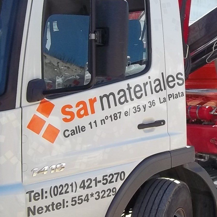 Un camión blanco con las palabras sarmateriales al costado.