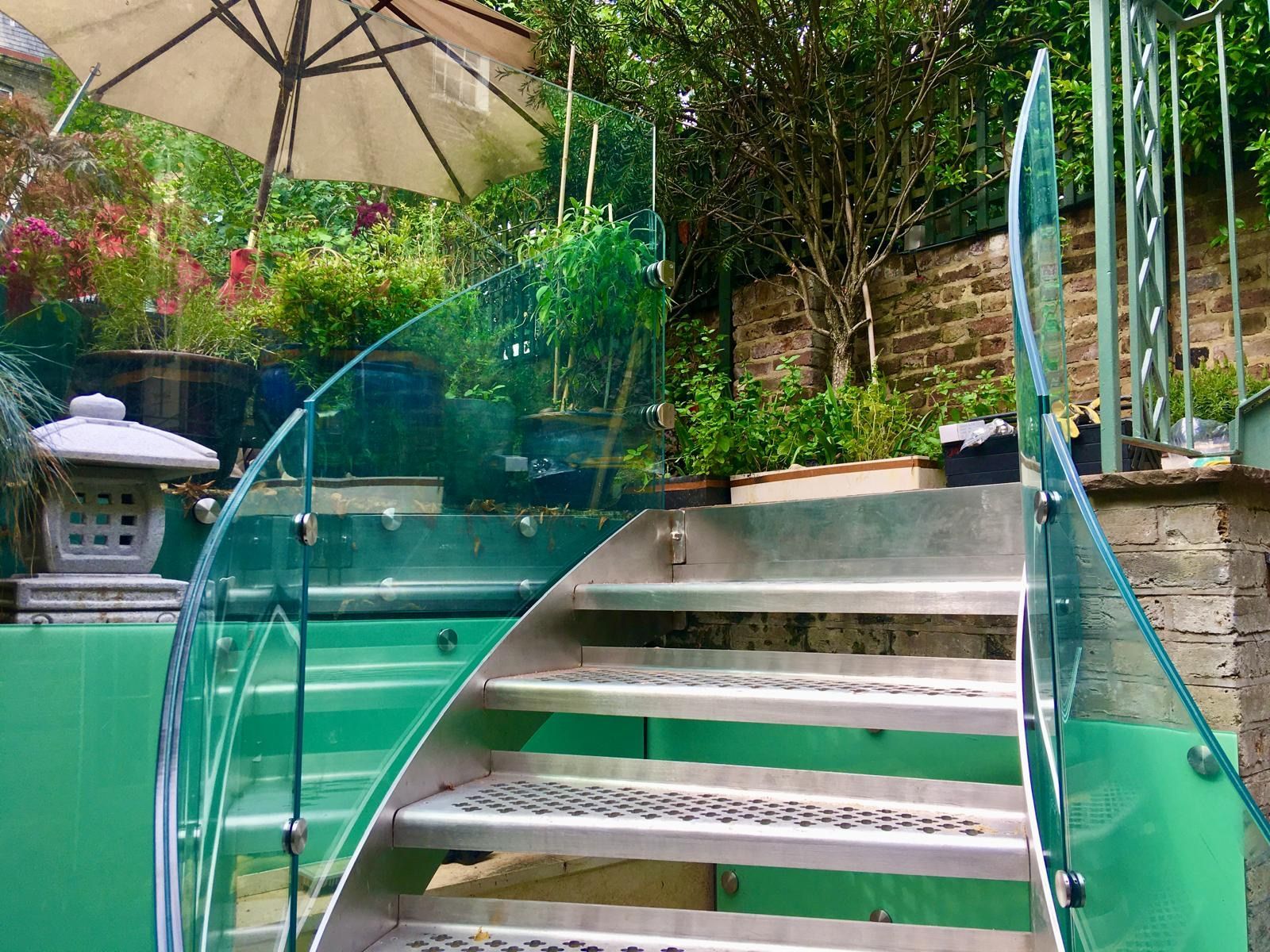 Outdoor curved glass balustrade and stainless steel staircase – garden installation