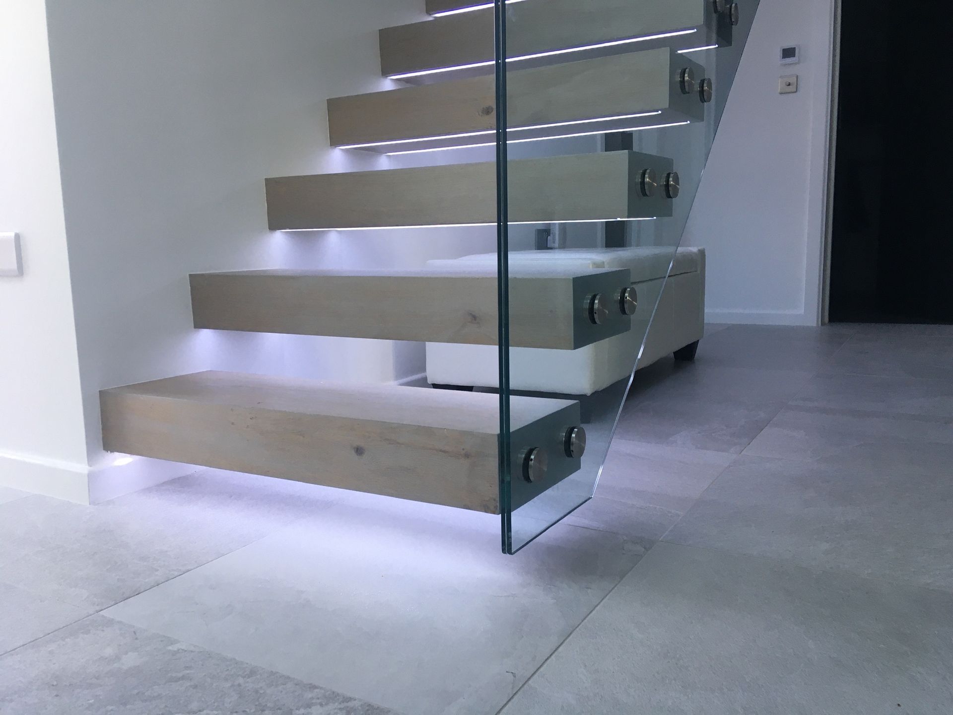 Floating staircase with LED lighting and glass balustrade – modern interior design