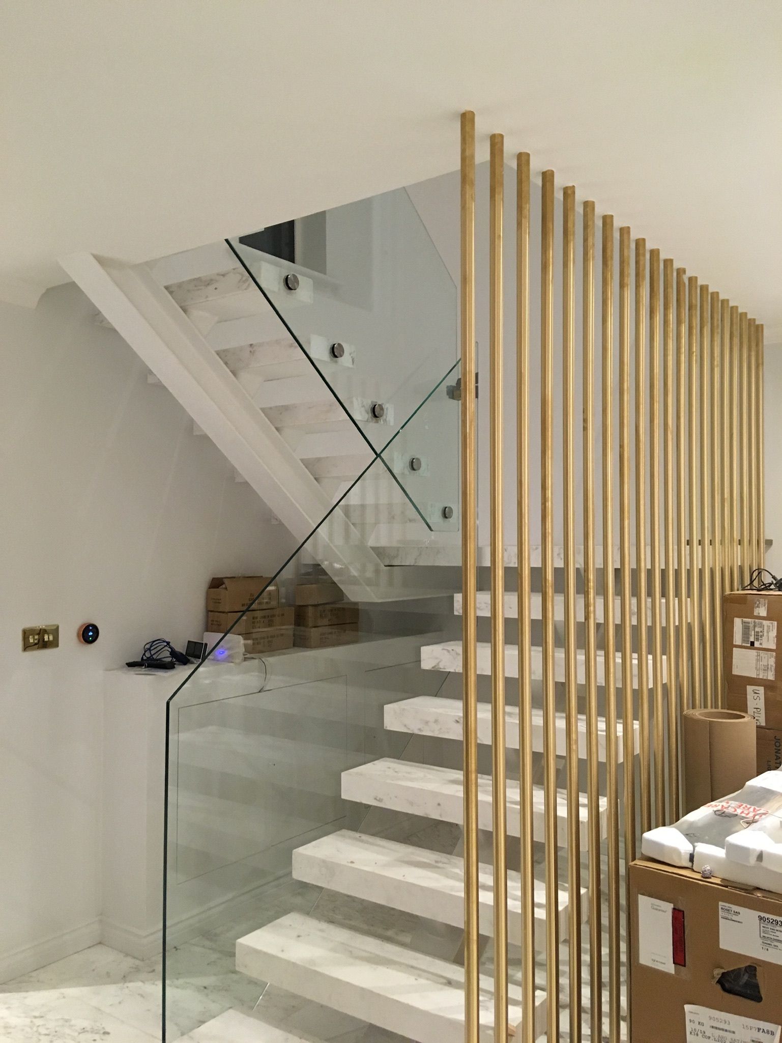 Glass and steel staircase with vertical brass balustrade – bespoke high-end interior, London