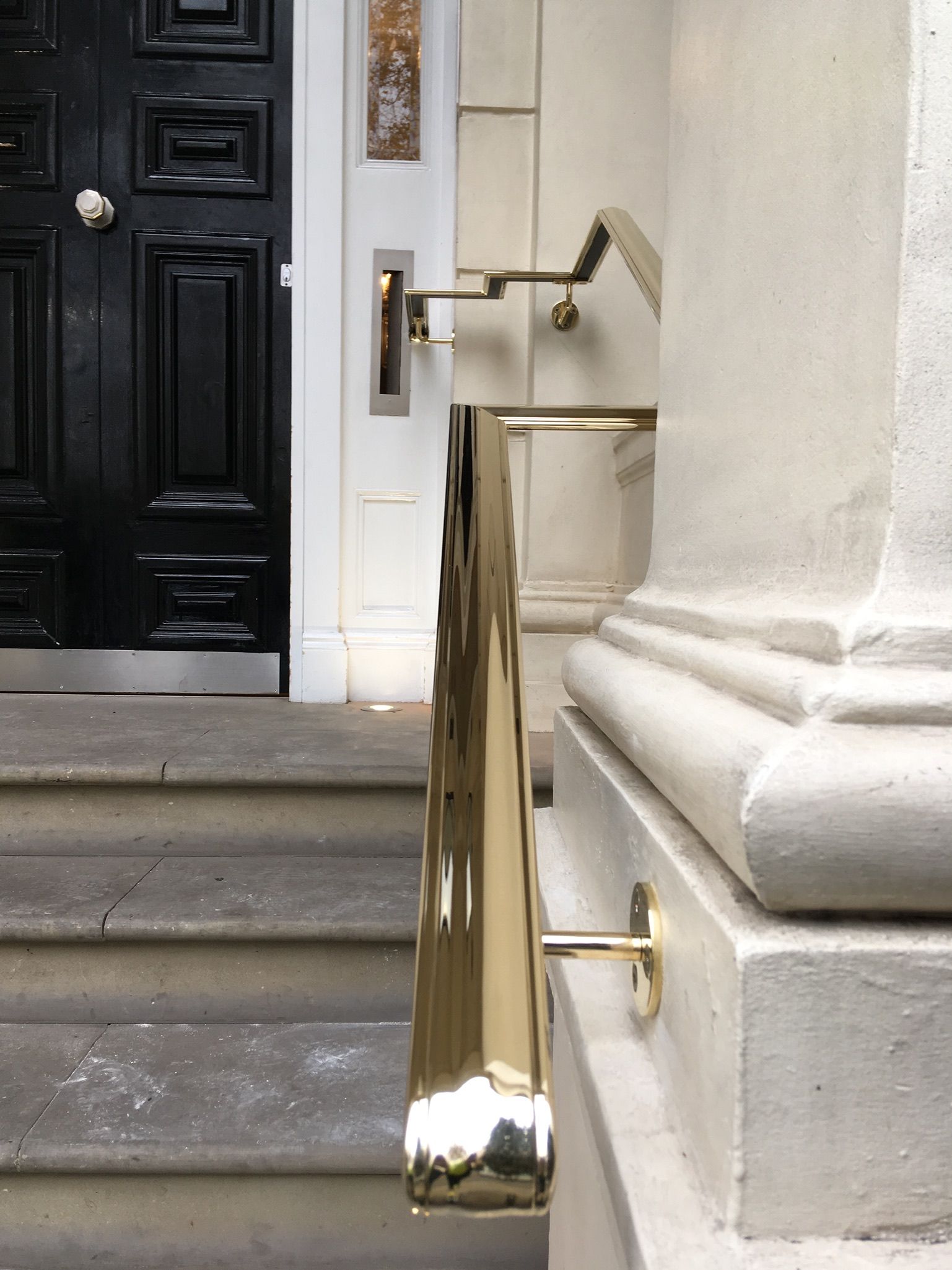 Brass handrail installed on stone wall – bespoke architectural detail, luxury London entrance