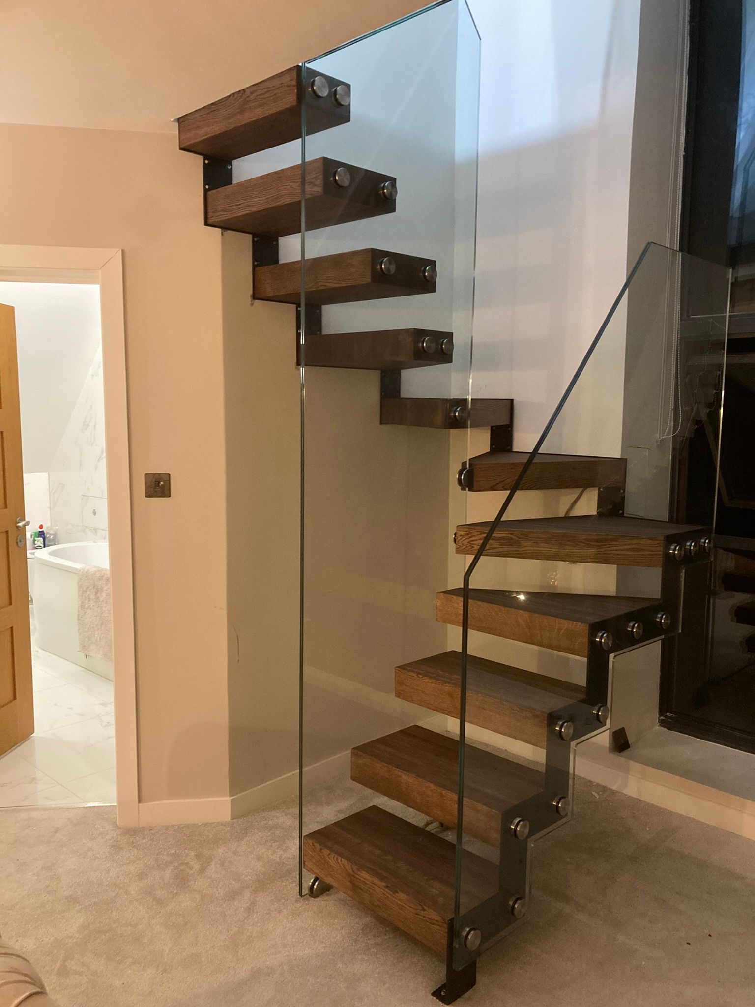Floating steel staircase with glass railing and hidden supports – minimalist design