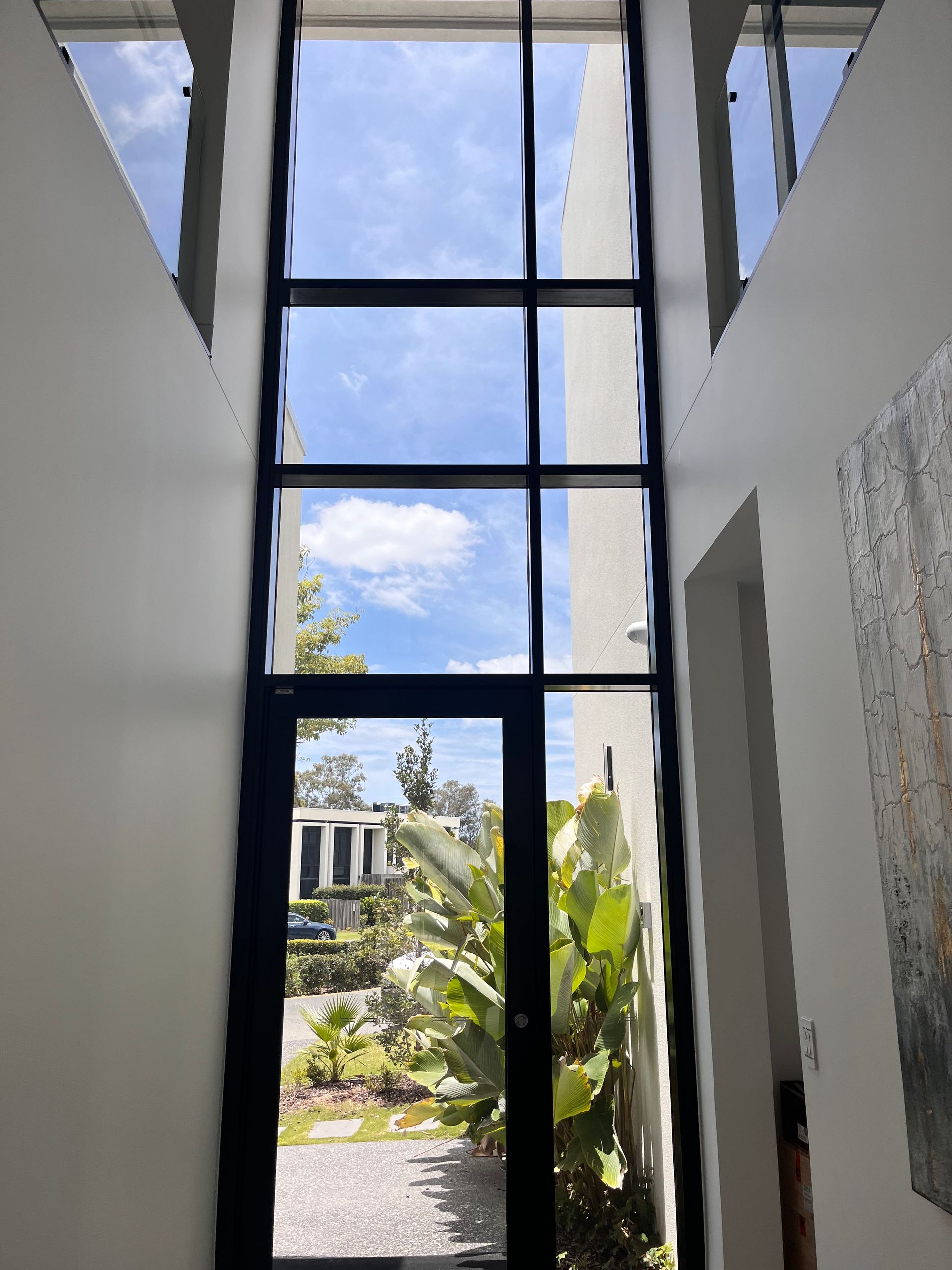 A hallway with a large window looking out to the sky