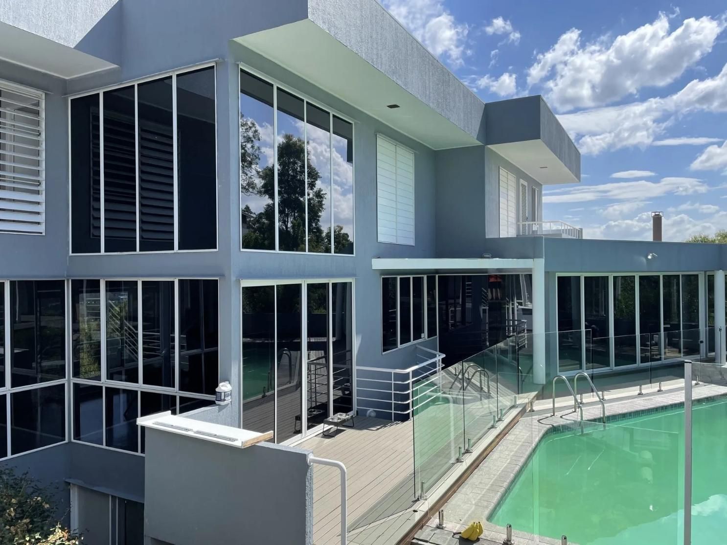 A Large House with A Swimming Pool in Front of It — Solarmaster in East Brisbane, QLD