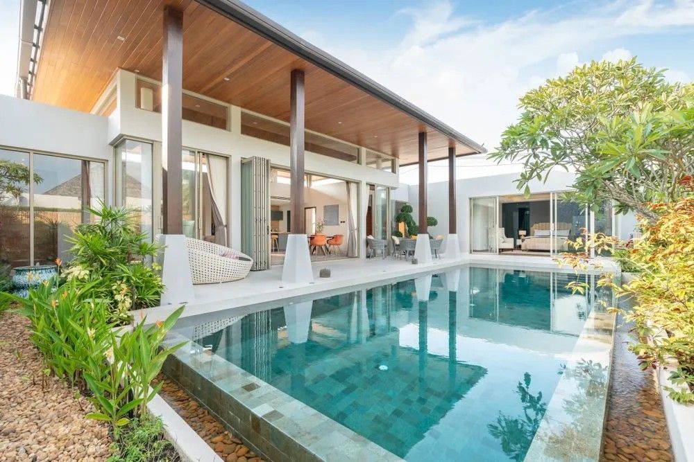 A Large House with A Swimming Pool in Front of It — Solarmaster in Southport, QLD