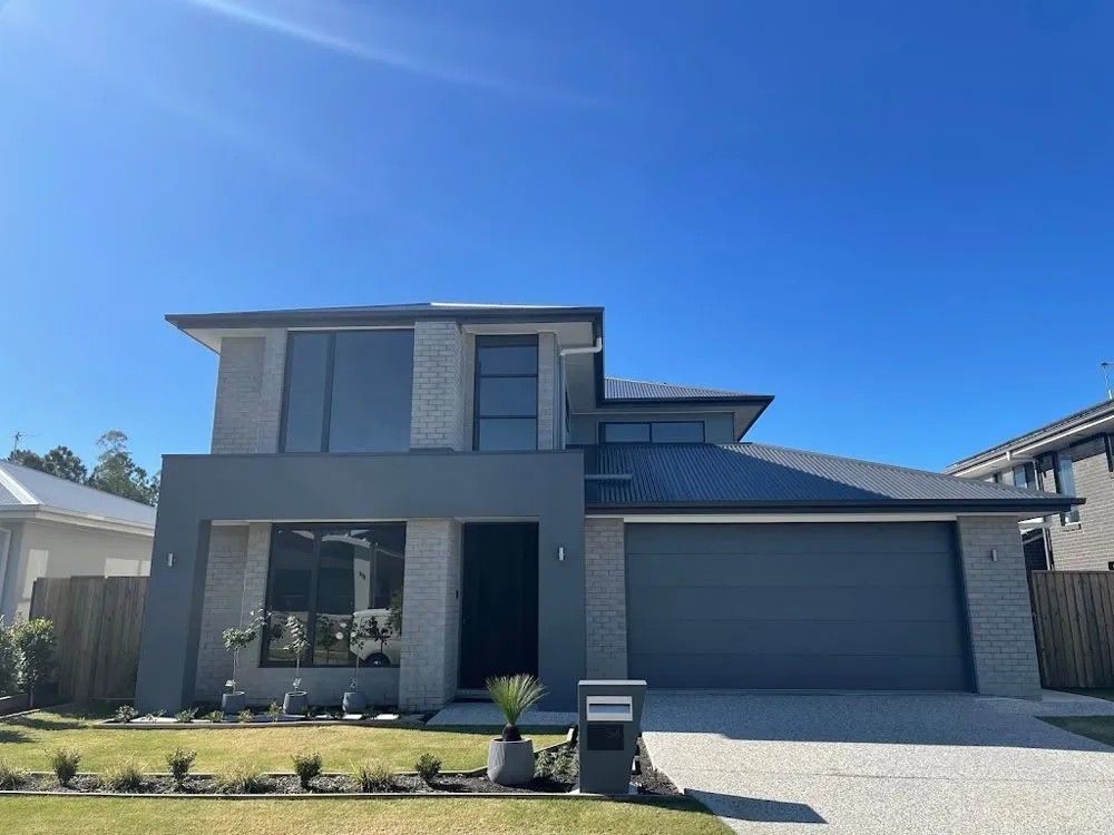 A Large Gray House with A Blue Sky in The Background — Solarmaster in Murarrie, QLD