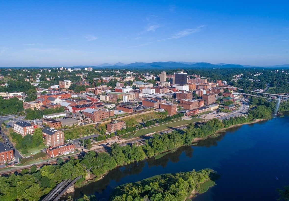 Small, cluttered commercial kitchen with stainless steel counter, microwave, sink, and various appliances.