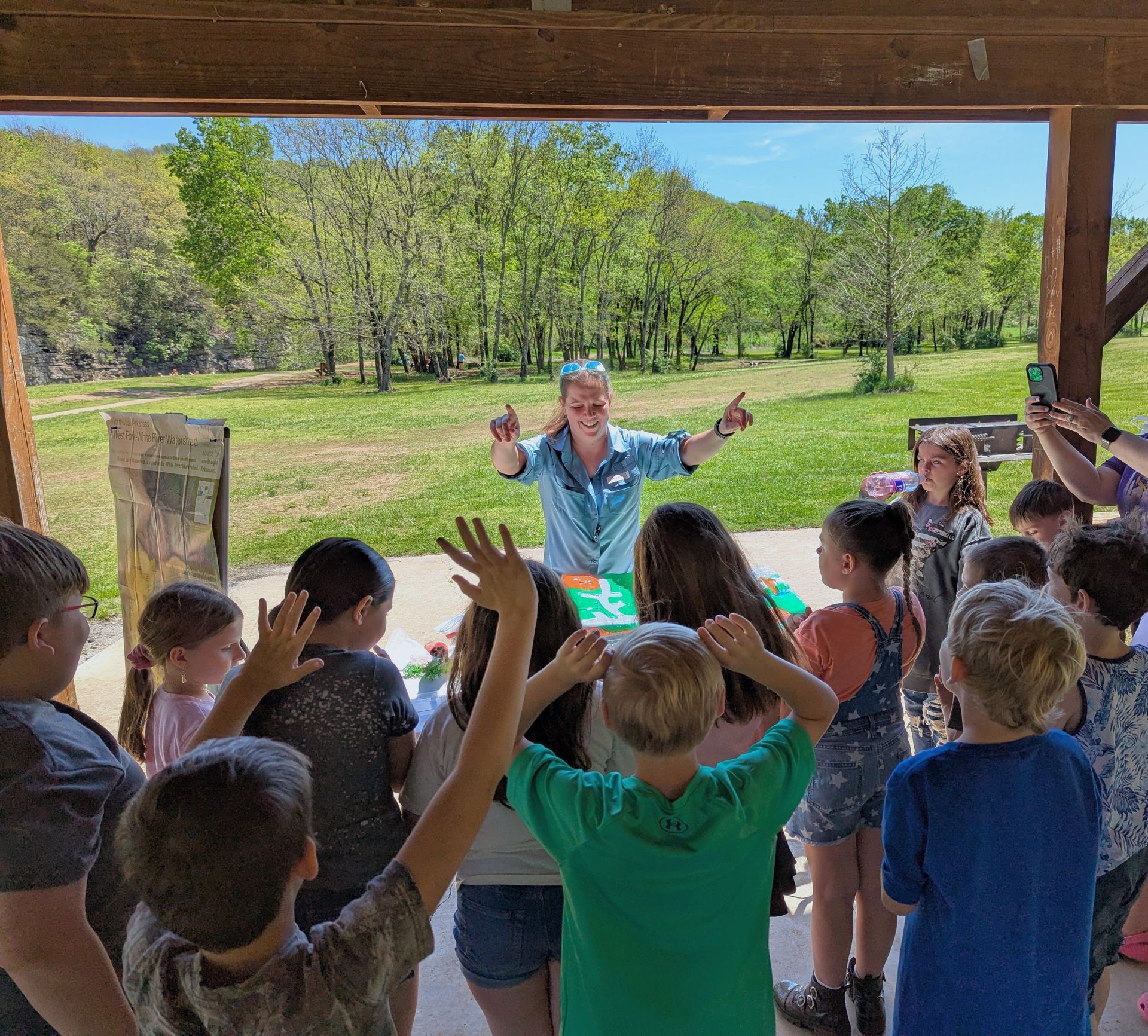 Ayla with the watershed table in front of a crowd of excited children