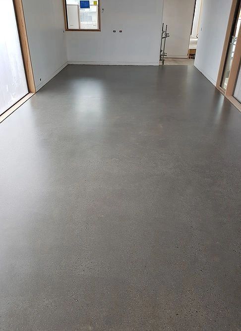 Empty room with polished concrete floor, natural light, and a window.