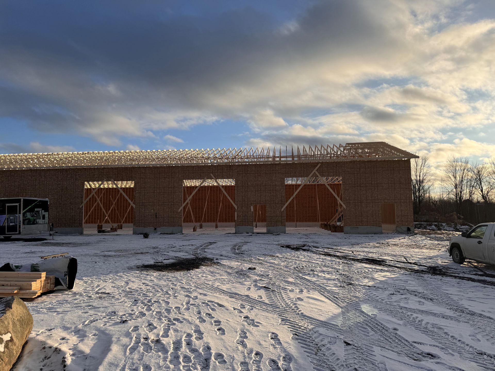 Un camion est garé devant un bâtiment en construction sous la neige.