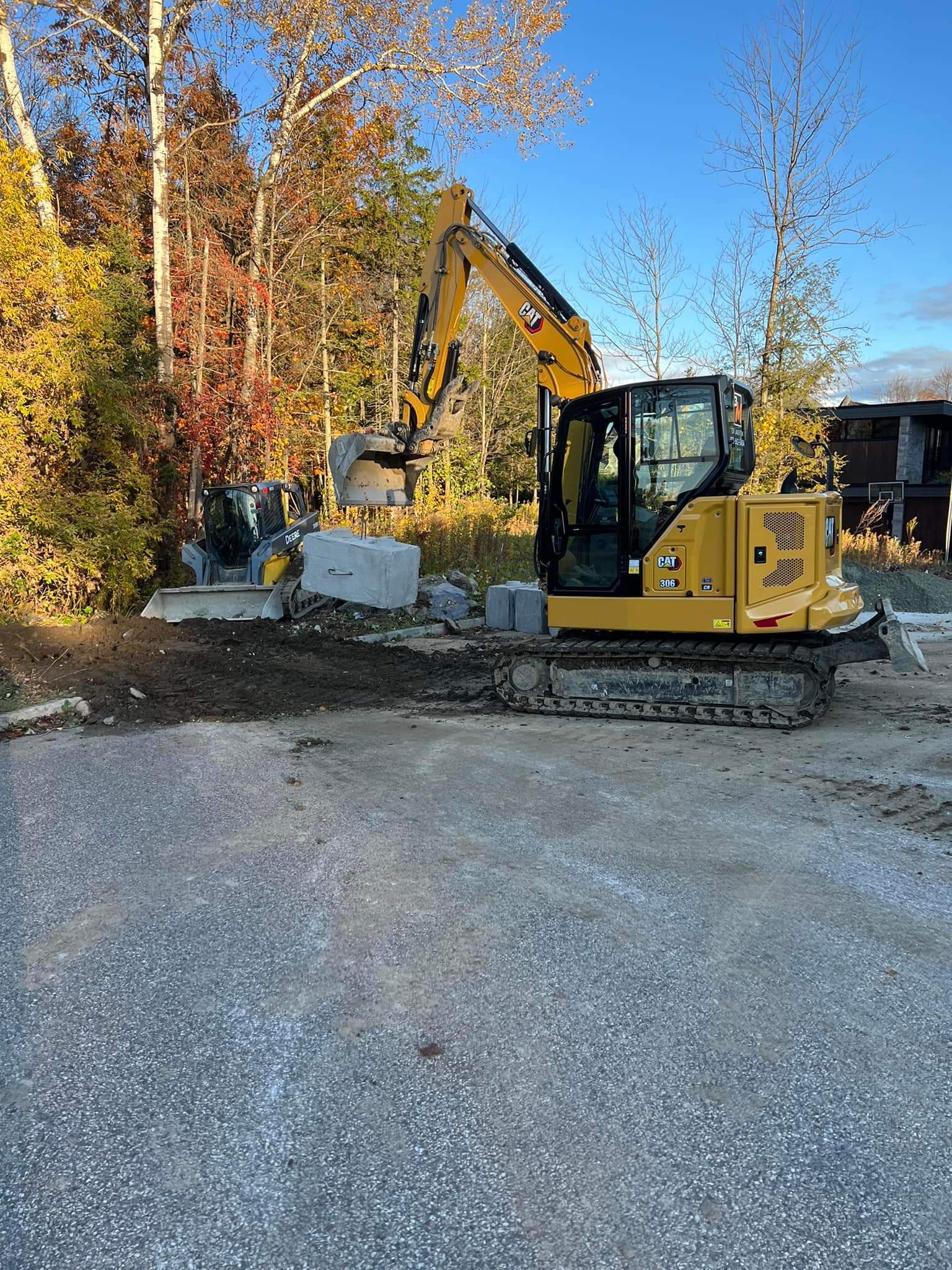 Une excavatrice jaune est assise dans un terrain de gravier.
