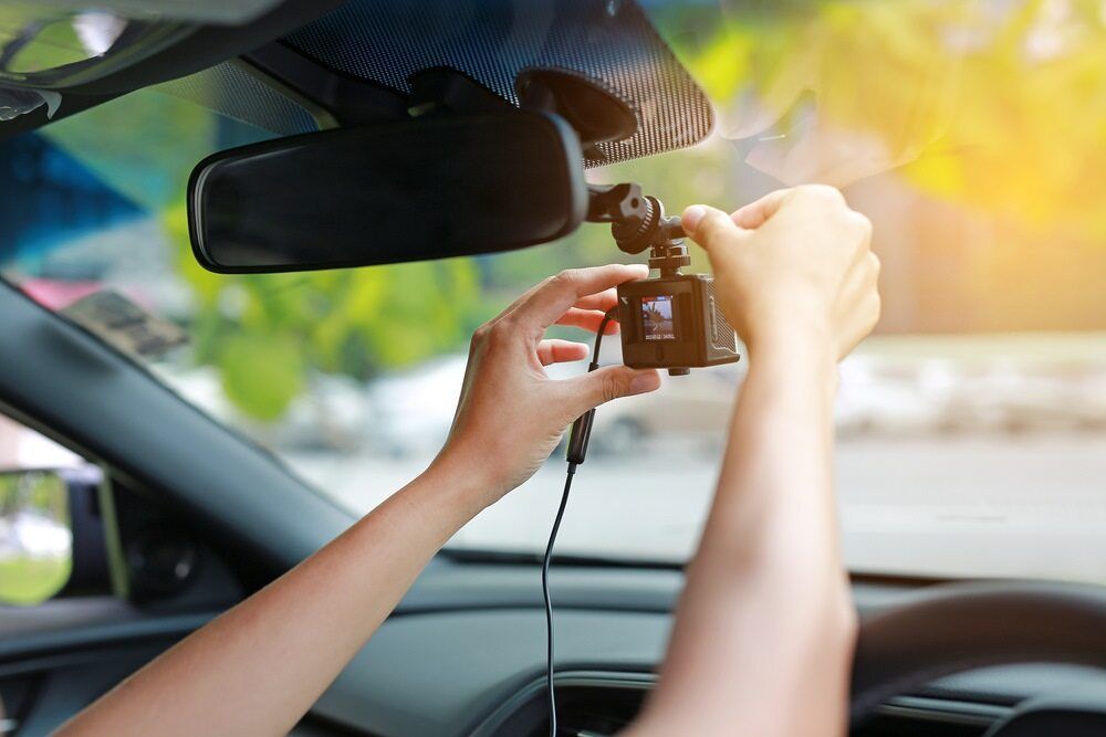 A person is installing a dash cam in a car — Townsville Car Audio Excellence in Townsville, QLD
