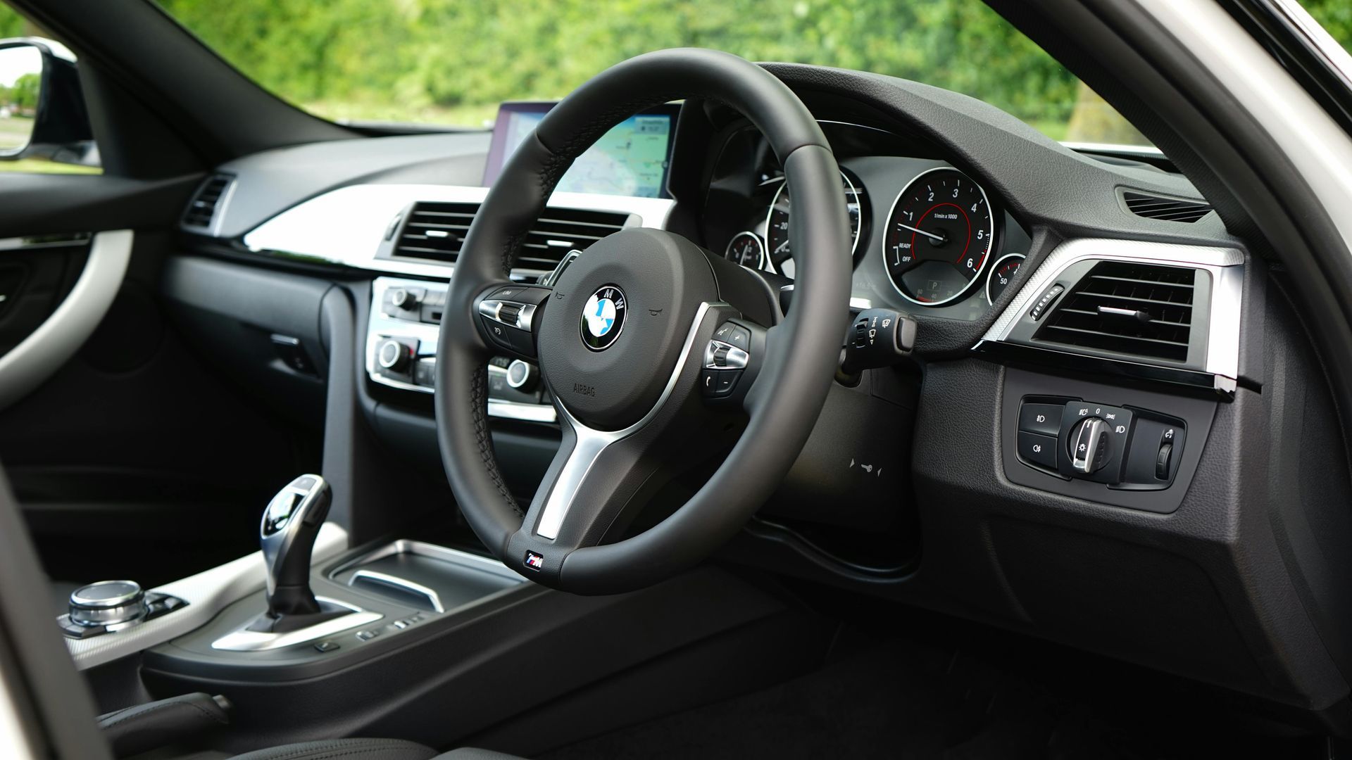 The interior of a bmw car with a steering wheel and dashboard — Townsville Car Audio Excellence in Townsville, QLD
