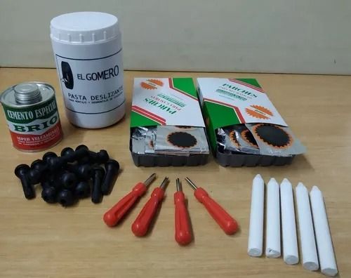 Componentes del kit de reparación de neumáticos pinchados: contenedor, parches, sellador, herramientas, tapones y velas.