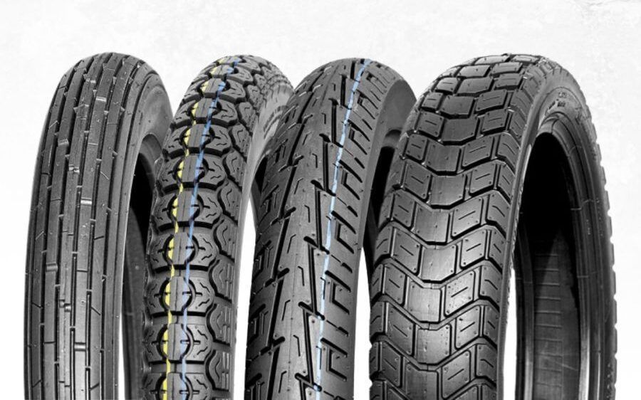 Cuatro neumáticos de motocicleta diferentes, con distintos patrones de banda de rodadura, alineados.