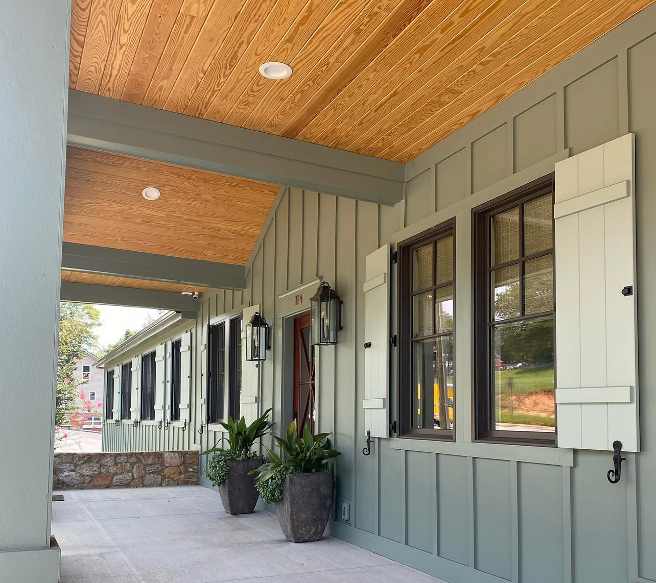 A porch of a house with shutters on the windows