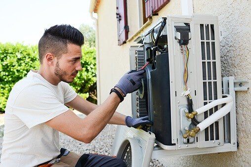 Professional Repairman repairing Air Conditioner — Air Conditioning Services in Bristow, VA