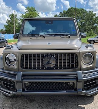 The front of a mercedes benz g63 amg is parked in a parking lot.