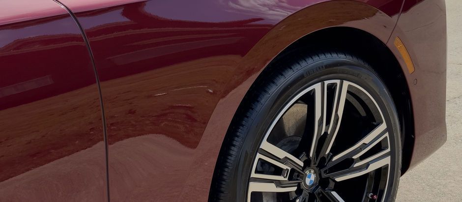 A close up of a red car 's wheel and tire.
