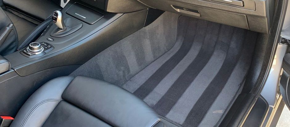 A close up of the interior of a car with a black carpet.