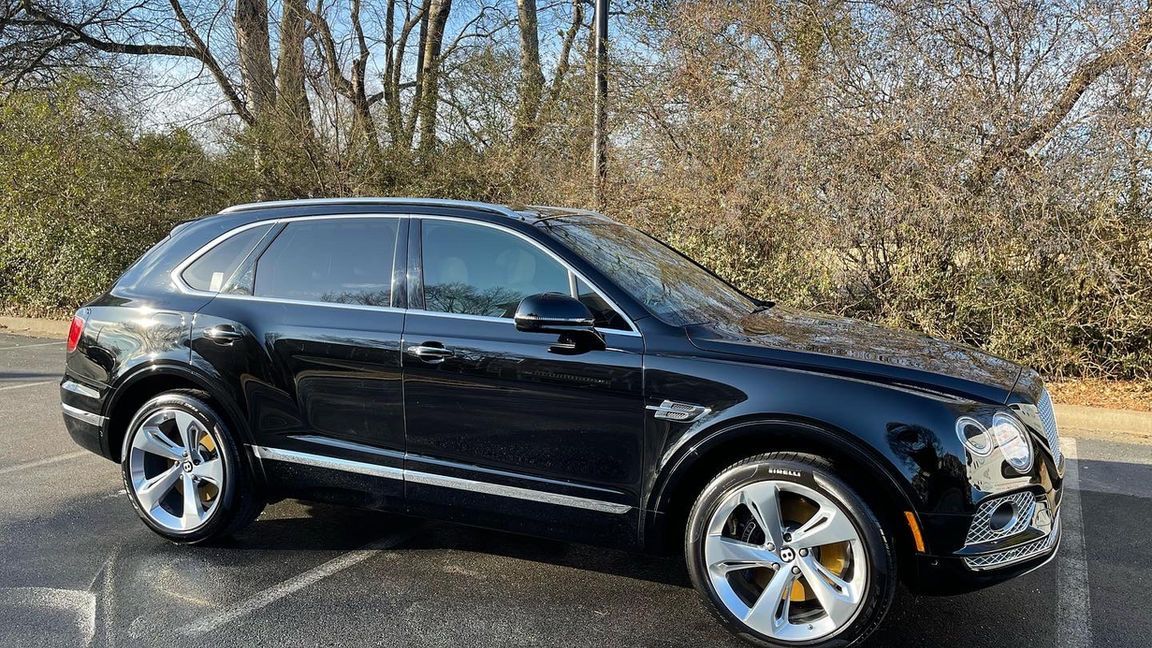 A black bentley continental gt is parked in a parking lot.
