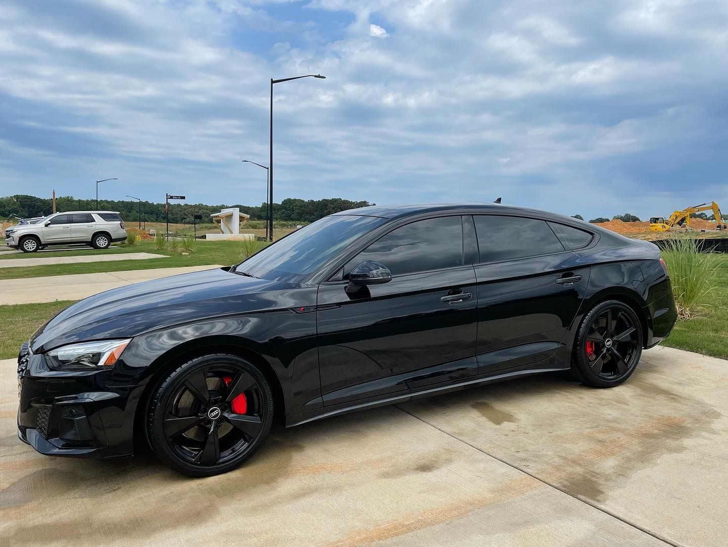 A black audi a5 is parked in a driveway.