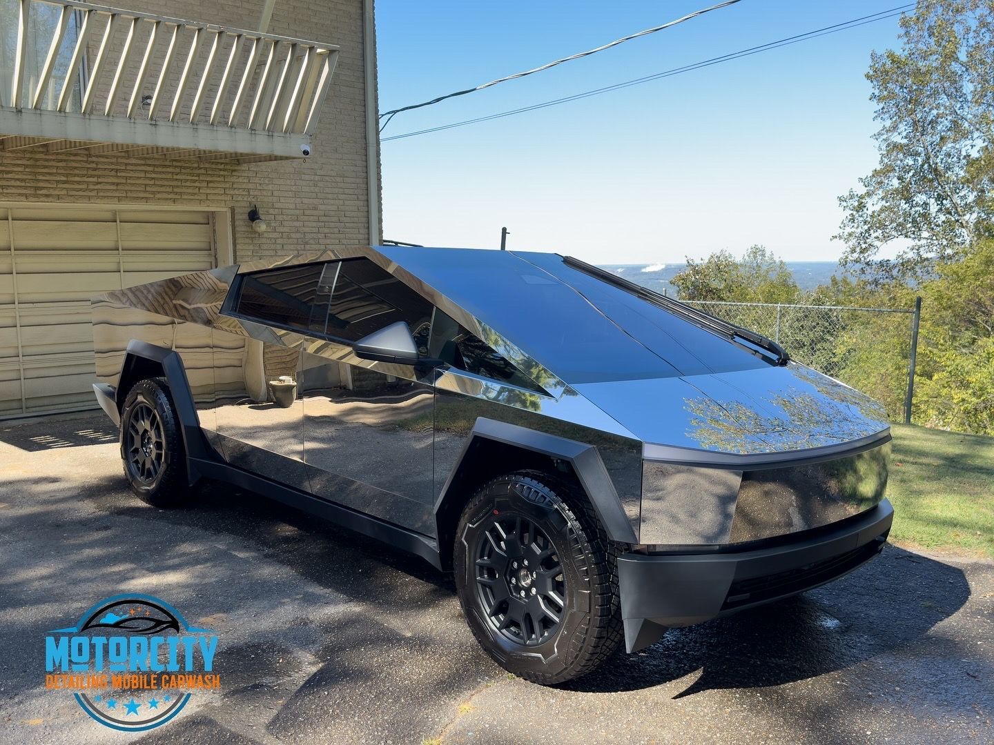 A tesla cybertruck is parked in front of a garage.