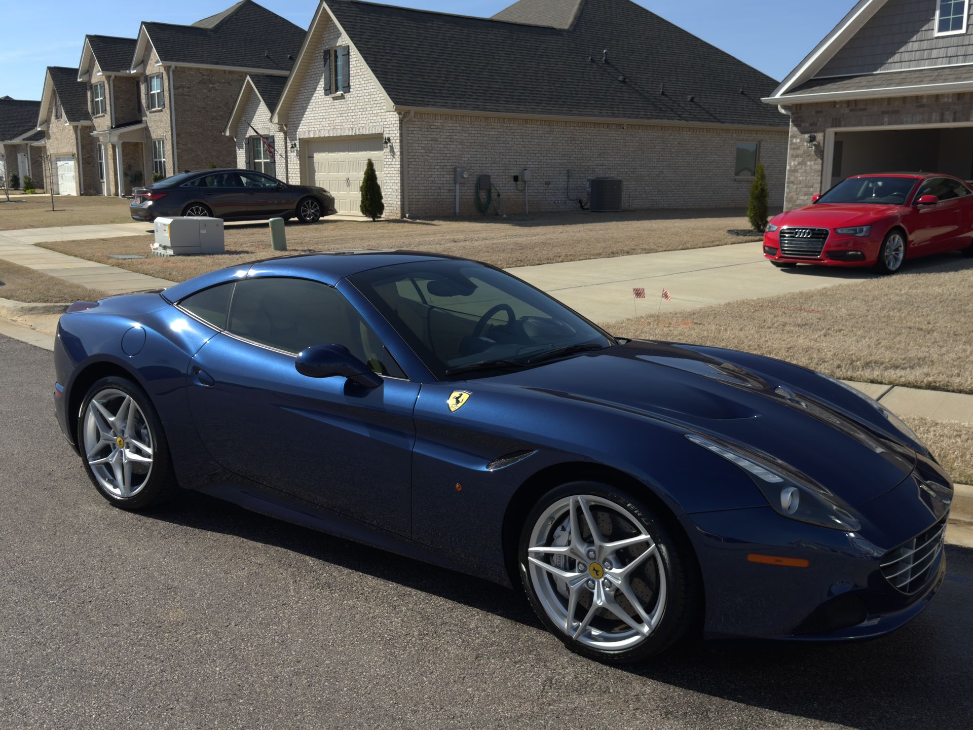 A blue sports car is parked on the side of the road