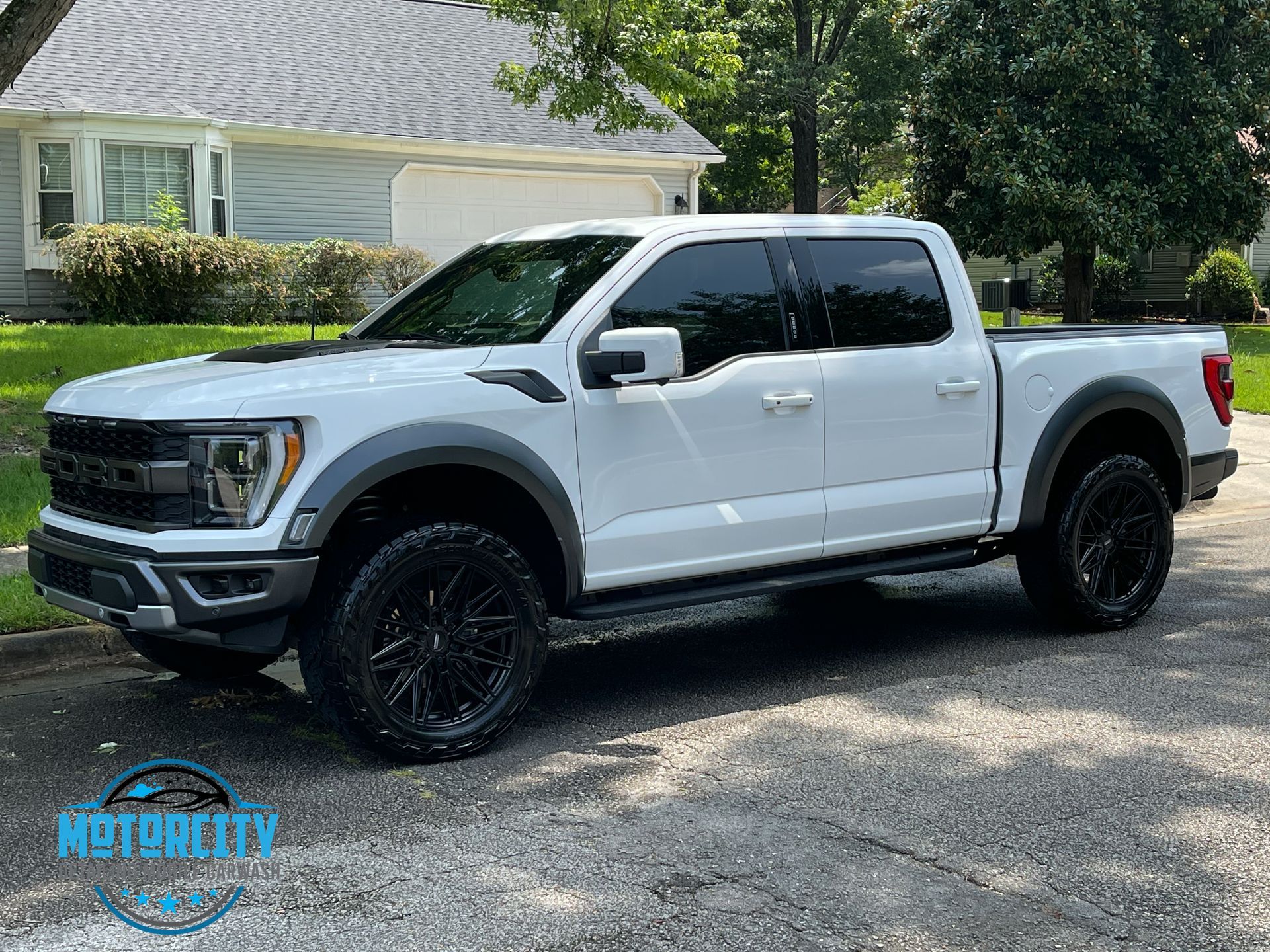 A white pickup truck is parked in front of a house.