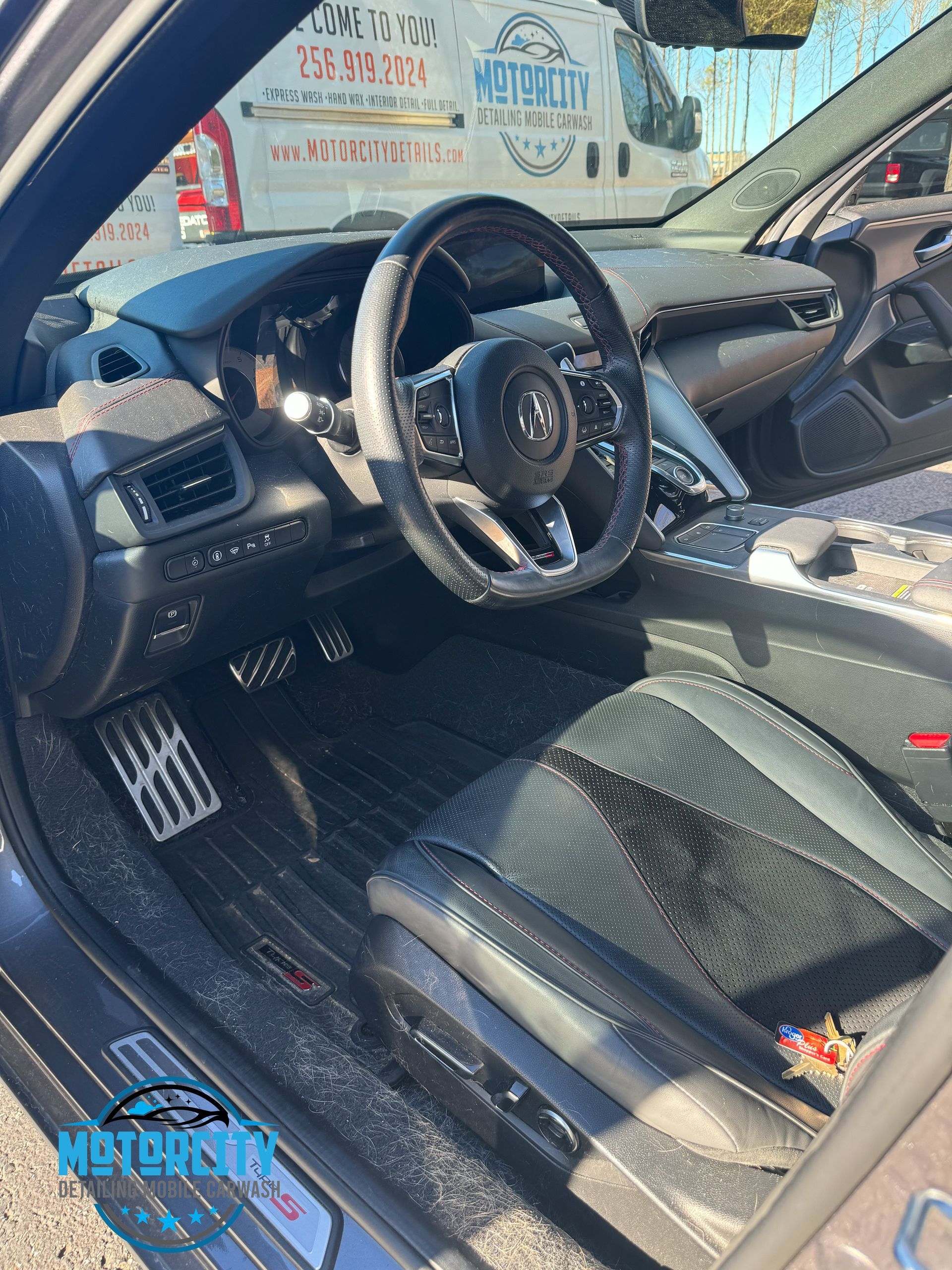 The interior of a car with a steering wheel and seats.