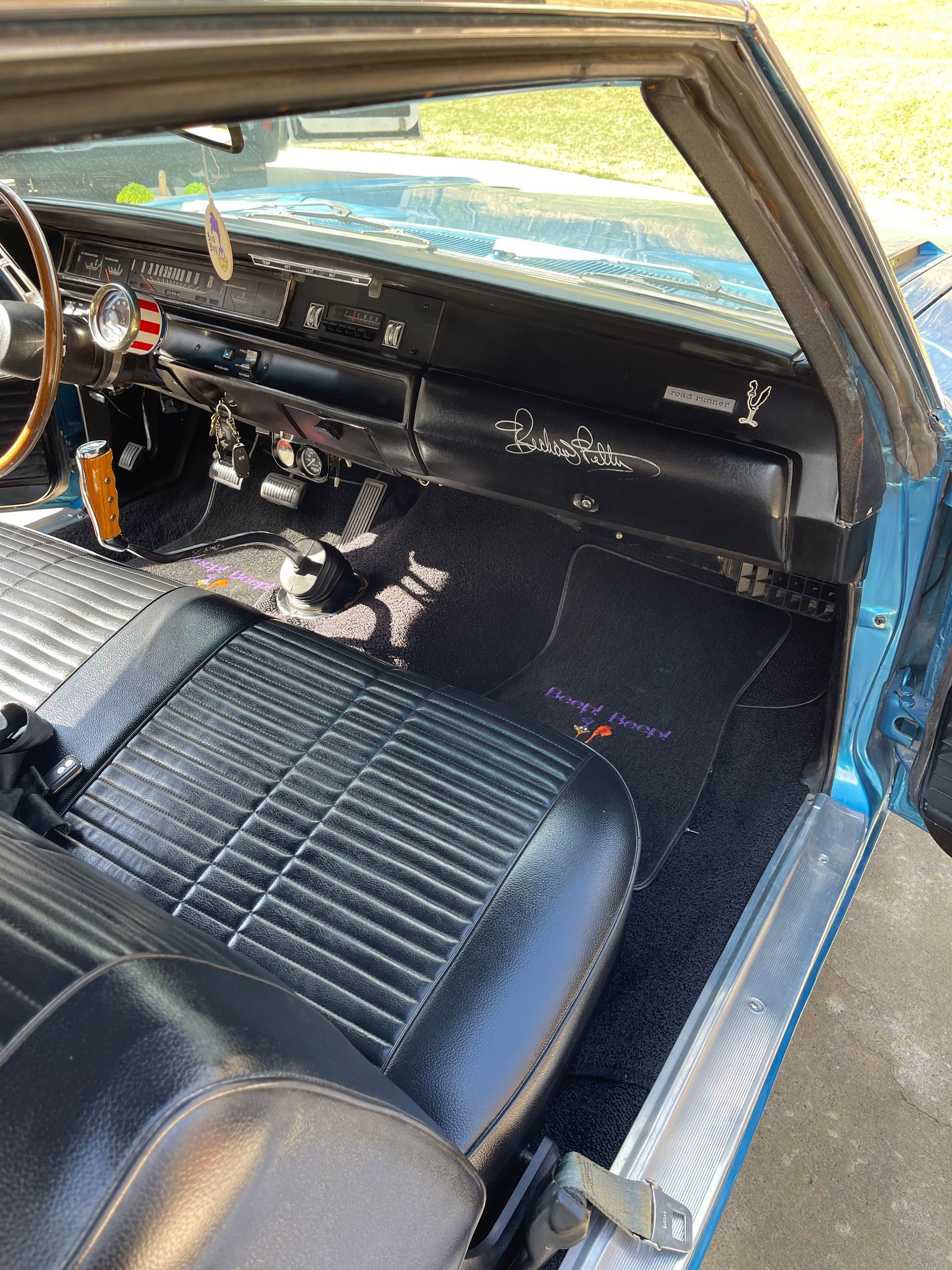 The interior of a blue car with the door open.
